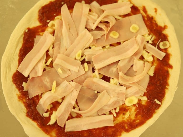 Frisch belegte Pizza vor dem Backen