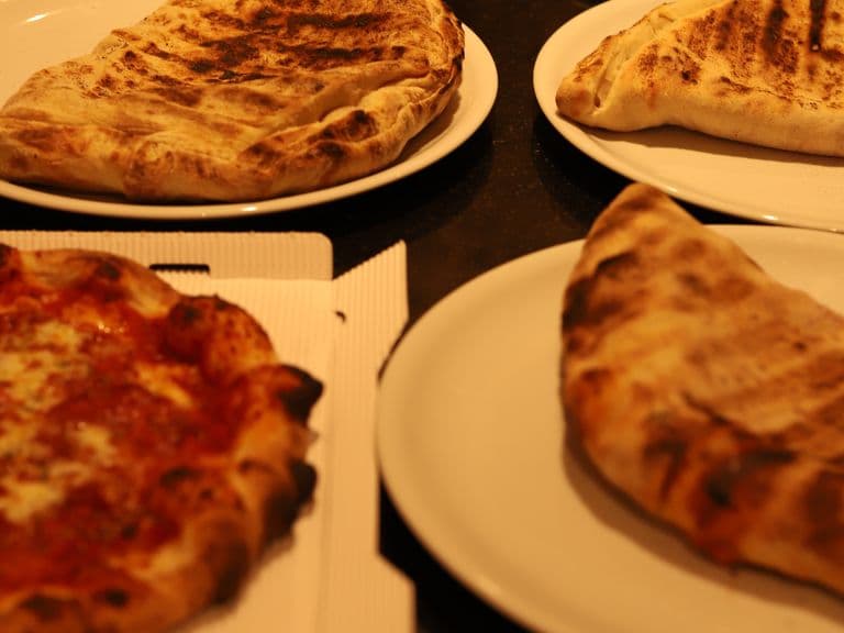 Mehrere Pizzen und Calzone bereit zum Servieren