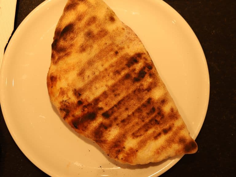 Goldbraun gebackene Calzone auf einem Teller